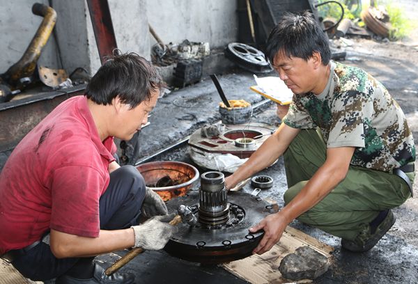 选运区维修班班长路续轩和工友对推土机变速箱部件进行整形 选运区维修班班长路续轩和工友对推土机变速箱部件进行整形